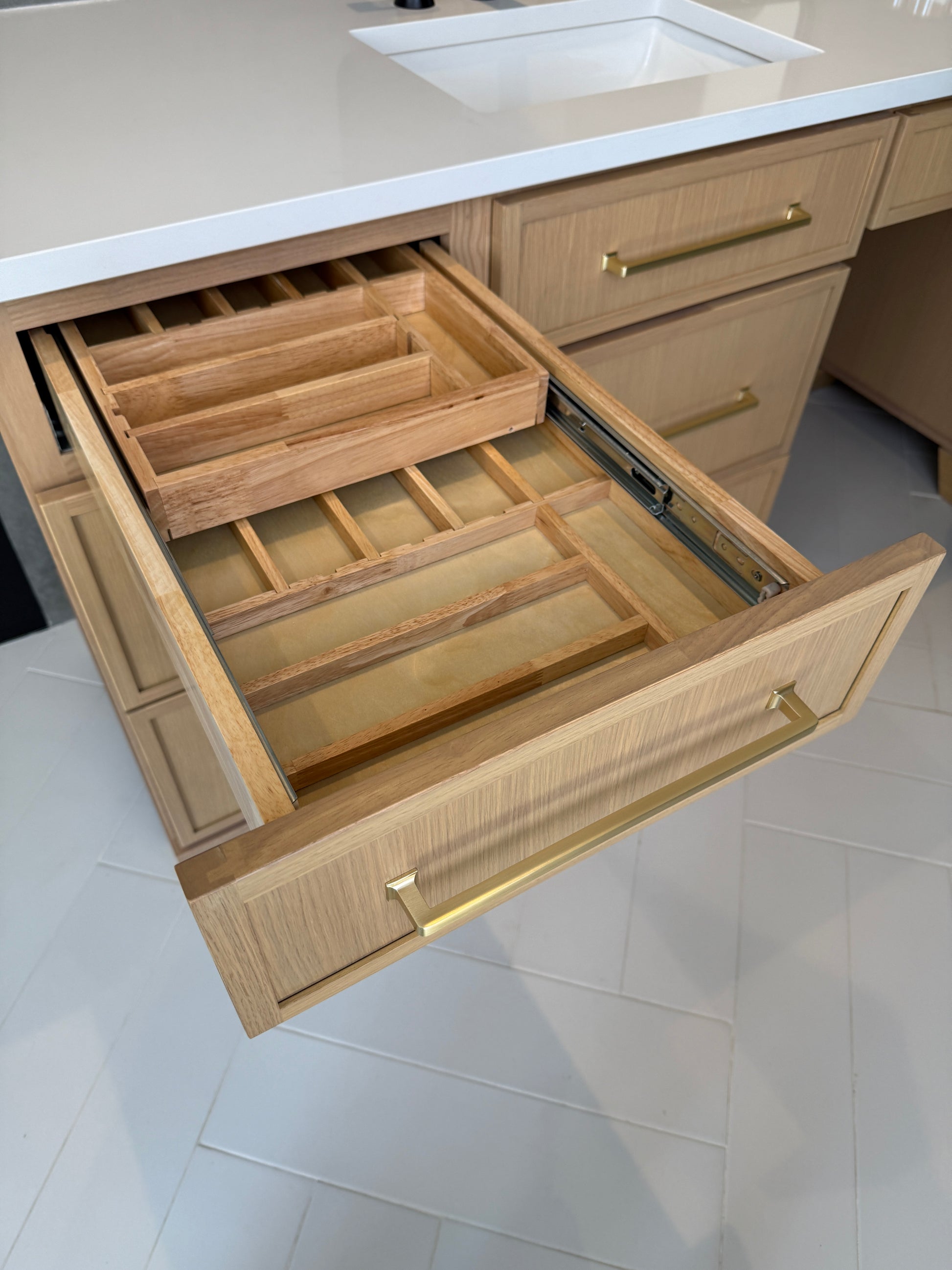 A Two-Tier Cutlery Drawer installed in a kitchen cabinet, displaying an organized arrangement of cutlery.