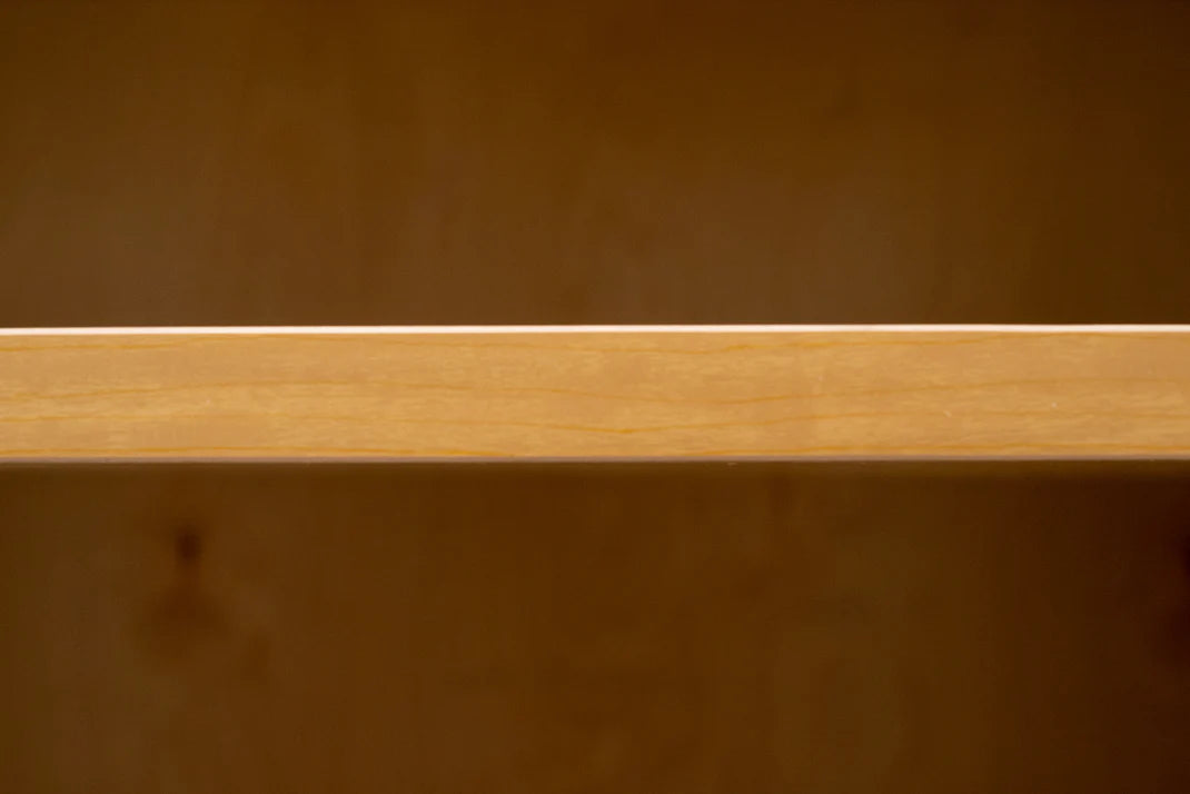 Close-up of a wooden surface with a visible grain pattern. cabinet three quarter inch thick shelf