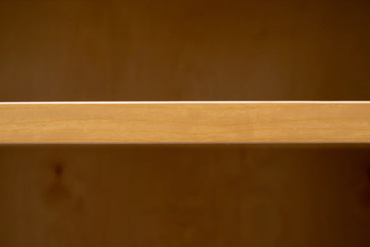 Close-up of a wooden surface with a visible grain pattern. cabinet three quarter inch thick shelf