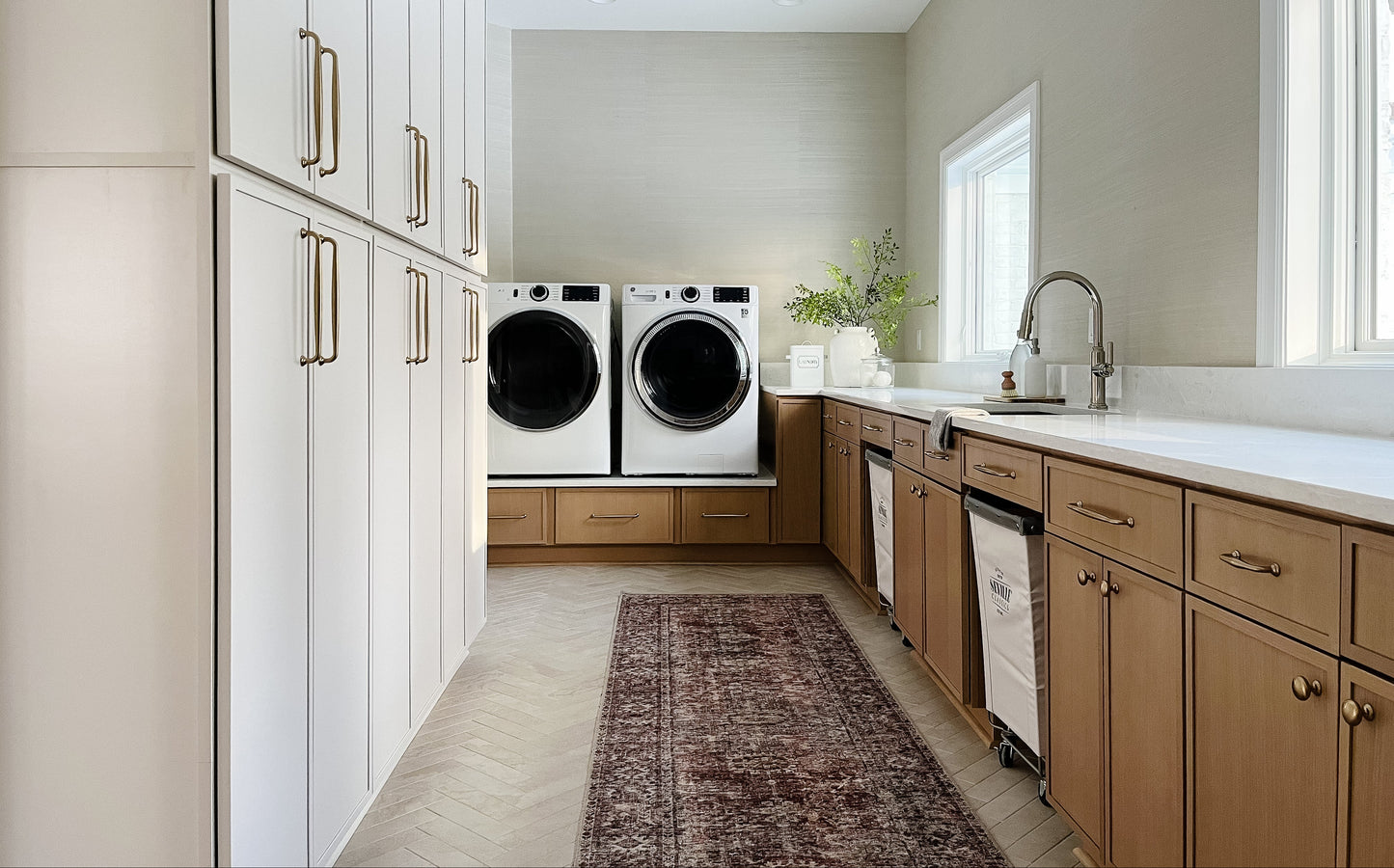 Modern laundry room with washer, dryer, and cabinets.