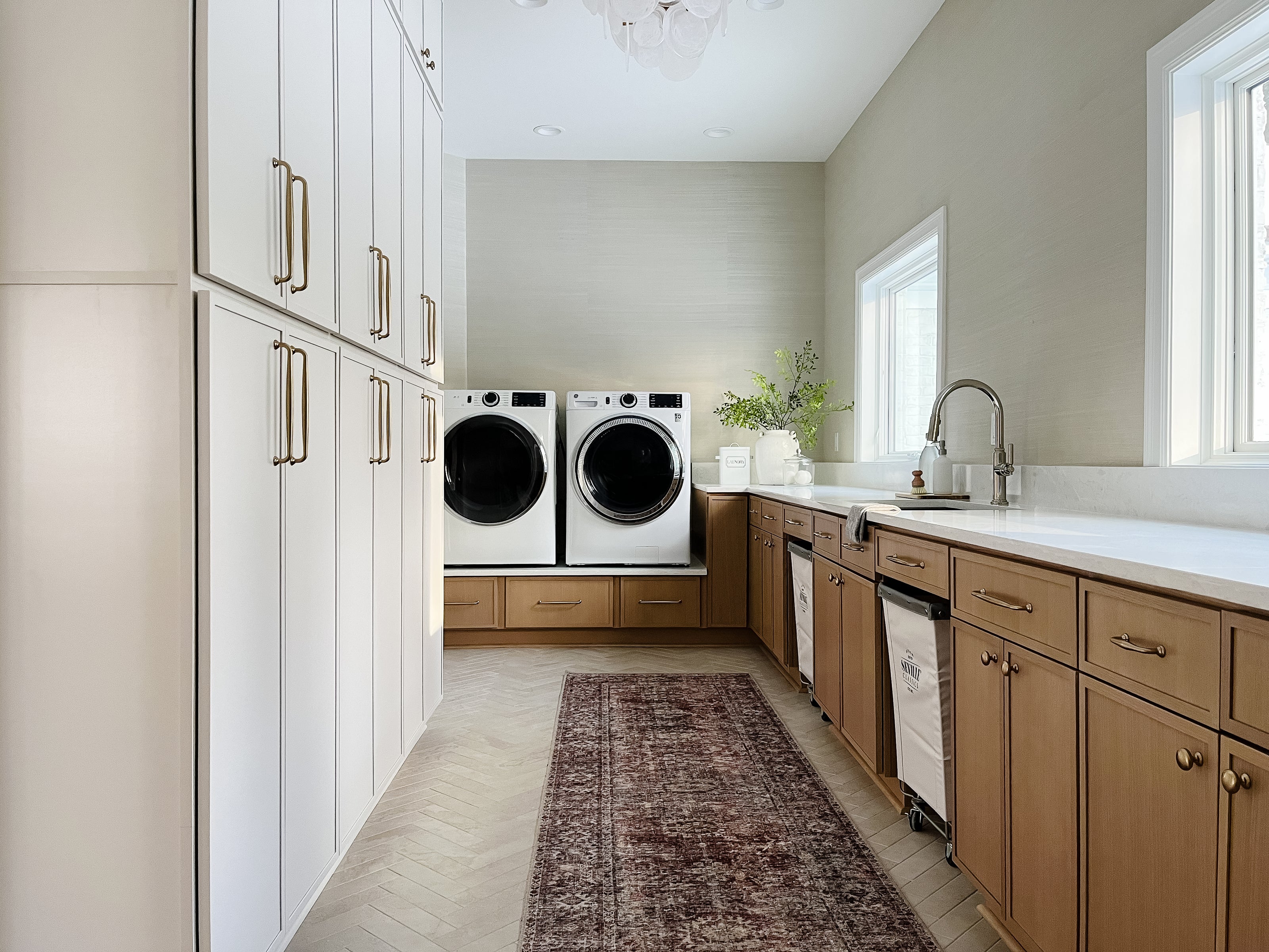 Modern laundry room with washer, dryer, and cabinets.